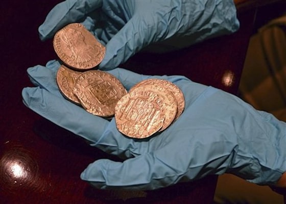 A member of the Spanish Culture Ministry's technical crew displays some of the 594,000 coins found in the Nuestra Senora de las Mercedes, a Spanish galleon sunk by British warships in the Atlantic while sailing back from South America in 1804.